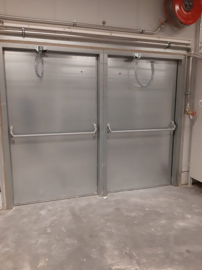 Twee enkele brandwerende deuren met kliksystemen in het grijs voor Colruyt Ans