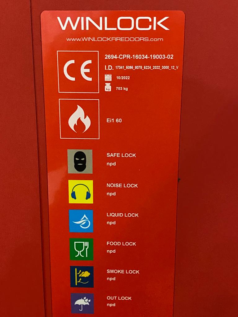 Rode EI1 60 brandwerende sectionaalpoort met safe lock, noise lock, liquid lock, food lock, smoke lock en out lock voor DHL in Boortmeerbeek