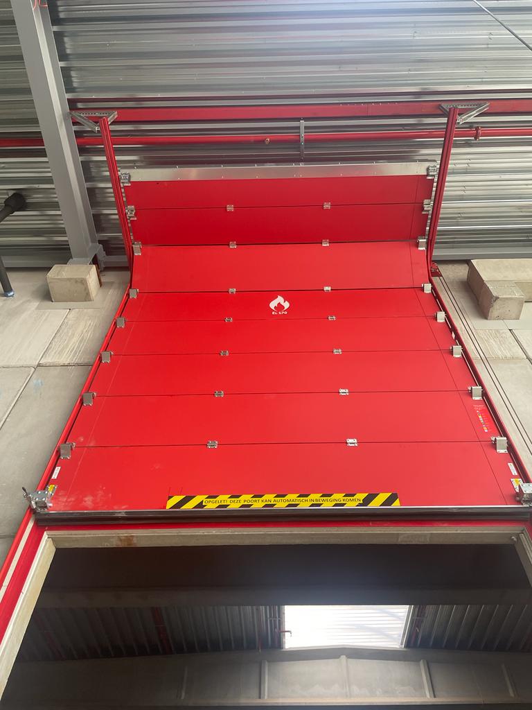 Rode EI1 120 brandwerende sectionaalpoort voor Van Wellen Storage in Antwerpen